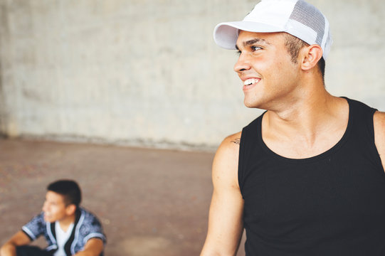 Portrait of hispanic young break dancer warming up urban park with concrete wall on background