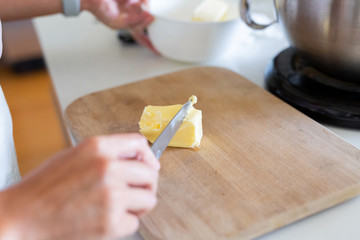woman cutting stick of butter for icing
