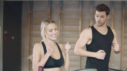Pretty woman getting results on treadmill. Athletic lady making yes gesture.