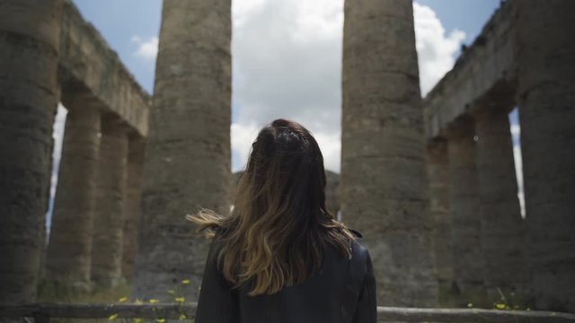 Rear view of woman standing by temple of Segesta in Sicily