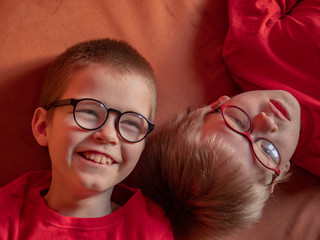  Funny children in red clothes posing in front of camera. Boys actively express their emotions. Preschoolers are happy together at home on vacation