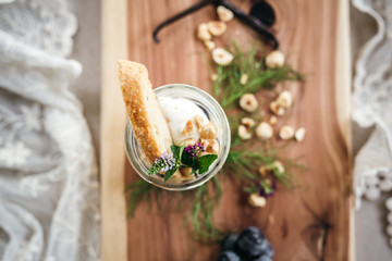 Vanilla Panna Cotta with a Concord Grape Gelee Topped with Whipped Chantilly Cream and Toasted Hazelnut and Served with a Slice of Hazelnut Biscotti