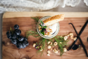 Vanilla Panna Cotta with a Concord Grape Gelee Topped with Whipped Chantilly Cream and Toasted Hazelnut and Served with a Slice of Hazelnut Biscotti