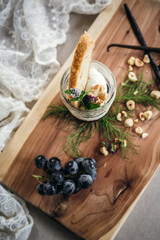 Vanilla Panna Cotta with a Concord Grape Gelee Topped with Whipped Chantilly Cream and Toasted Hazelnut and Served with a Slice of Hazelnut Biscotti