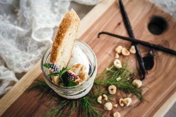 Vanilla Panna Cotta with a Concord Grape Gelee Topped with Whipped Chantilly Cream and Toasted Hazelnut and Served with a Slice of Hazelnut Biscotti