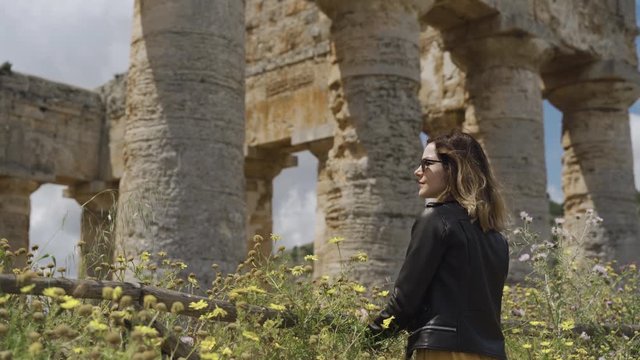 Woman standing by ancient ruins temple of Segesta in Sicily