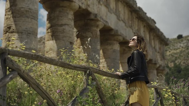 Woman standing by ancient ruins temple of Segesta in Sicily