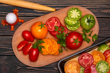 Cooking vegetarian pizza with different types of tomatoes