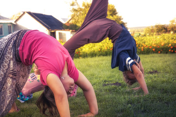 Happy children making exercise yoga outdoors on grass concept healthy childhood lifestyle