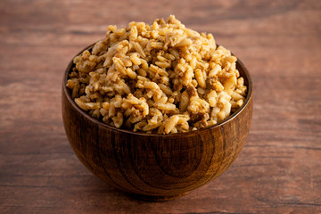 Bowl of Cajun Dirty Rice on a Rustic Wooden Table