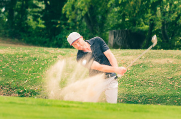 A golf pro with a perfect bunker shot. - Powered by Adobe