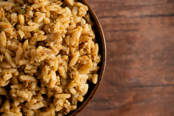 Bowl of Cajun Dirty Rice on a Rustic Wooden Table