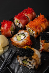 Sushi roll Philadelphia with salmon, smoked eel, avocado, cream cheese on black background. Sushi menu. Japanese food.