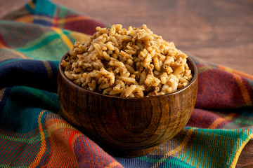 Bowl of Cajun Dirty Rice on a Rustic Wooden Table