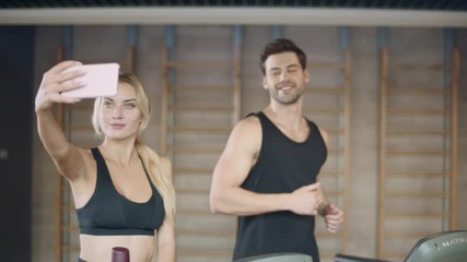 Smiling couple making selfie in sport club after training.