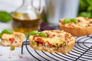 Mini tarts with meat, green peas, tomatoes, Provence herbs and cheese