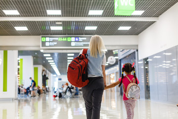Mother and little girl in airport waiting for boarding