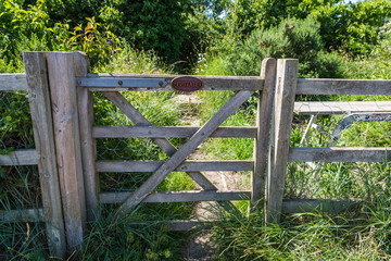 Private farm land fenced off by a large gate with a private keep out sign showing no access to the...