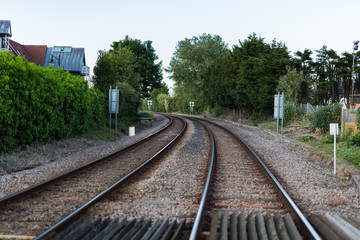 An empty train track, there are 2 tracks leading to a point on the horizon in rural countryside
