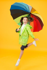 I do not care. Carefree schoolgirl jumping with umbrella waterproof rain coat. Autumn rain. Rainy...