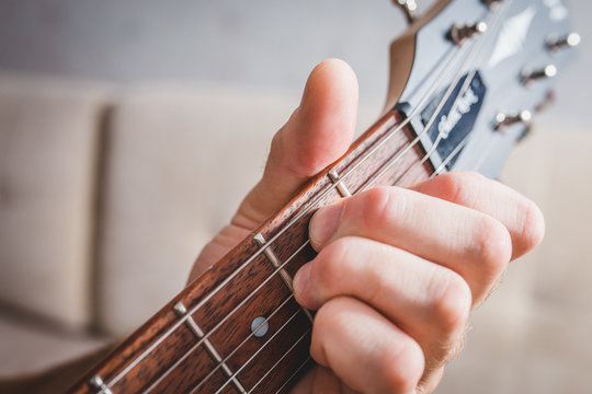 E chord - close-up male Caucasian hand takes a chord on a 6 string guitar