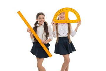 Geometry lesson is much fun. Little girls holding protractor and ruler for lesson. Small children...