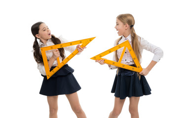 Fototapeta A lesson for the future. Small children with measuring instruments at school lesson. Little girls preparing for geometry lesson. Cute schoolgirls holding triangular rulers for lesson obraz