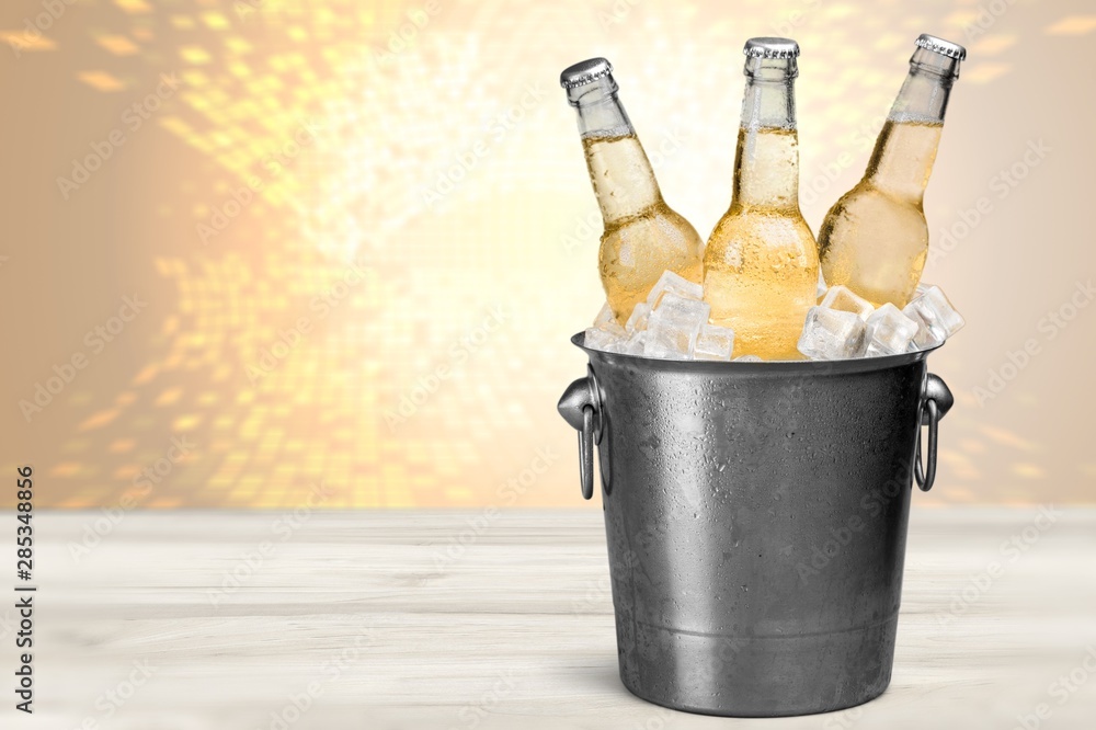 Wall mural beer bottles in bucket with ice cubes isolated on white