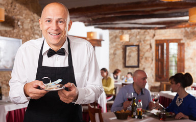 Fototapeta na wymiar Happy waiter with good tips