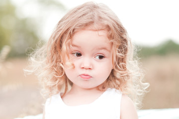 Cute baby girl 2-3 year old posing outdoors. Summer season. Pretty child girl. Childhood.
