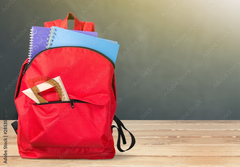 Sticker Colorful school supplies in backpack on wooden background