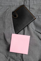 Small little wallet inside man trousers front pocket near notation paper