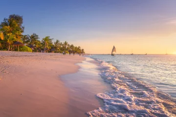 Keuken spatwand met foto Sandy beach with sea waves, palm trees and walking people at colorful sunset in summer.  Tropical landscape with blue sea, palms, boats and yachts in ocean, beautiful sky. Travel in exotic Africa © den-belitsky