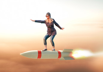 Frau surft auf Rakete über den Wolken - obrazy, fototapety, plakaty