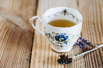 Thé au citron dans une tasse en porcelaine, table en bois