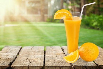 Glass of delicious orange juice on natural background