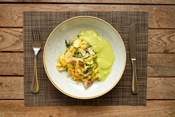 Pasta with bacon. Top view of beautiful dish on the wooden table in restaurant. Breakfast or dinner in  European street cafe. Eating italian food.