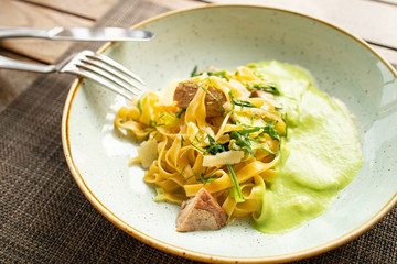 Pasta with bacon. Top view of beautiful dish on the wooden table in restaurant. Breakfast or dinner in  European street cafe. Eating italian food.
