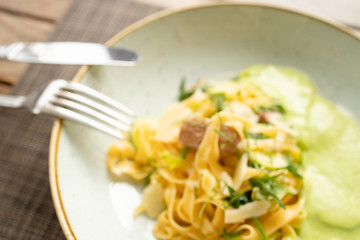 Pasta with bacon. Top view of beautiful dish on the wooden table in restaurant. Breakfast or dinner in  European street cafe. Eating italian food.