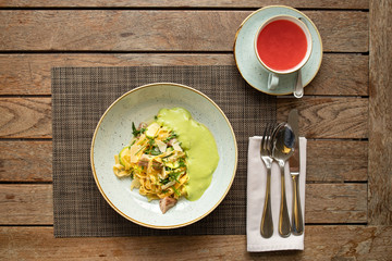 Pasta with bacon. Top view of beautiful dish on the wooden table in restaurant. Breakfast or dinner in  European street cafe. Eating italian food.