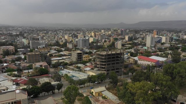 Ascending drone flight towards construction site and skyline of Mek' ele with residential and commercial neighborhoods, urbanization and development in Ethiopia Africa
