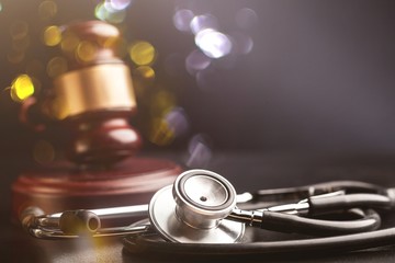 Gavel and stethoscope on wooden background, symbol