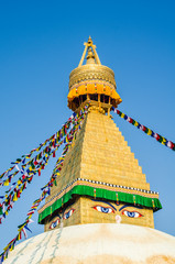 The whitewashed dome and gold spire of Bodhnath Stupa, Kathmandu, Nepal, with Buddhist prayer flags