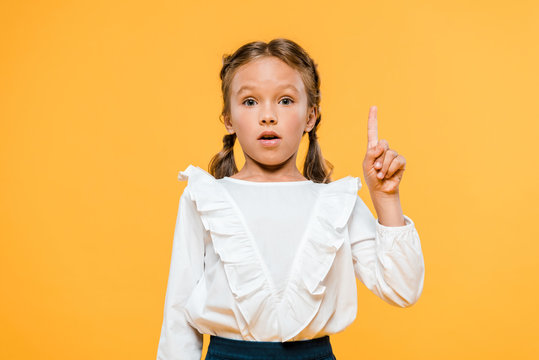 surprised schoolkid having idea isolated on orange