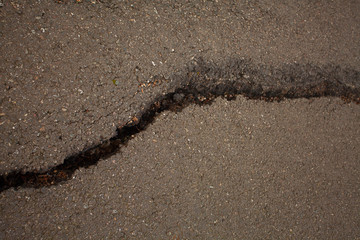 Fototapeta na wymiar photo of gray cracked asphalt pavement