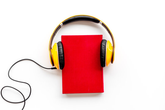 listen to audio books with headphone on white background flatlay