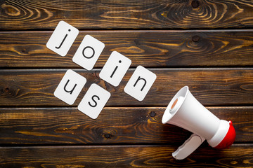 Join us text for announcement and megaphone on wooden background top view