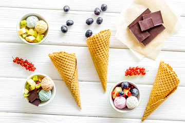 summer dessert with ice cream, cones, chocolate, berries on white wooden backgroung top view pattern