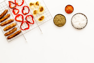 Barbecue with sausages, vegetables on grid and spices on white background top view space for text