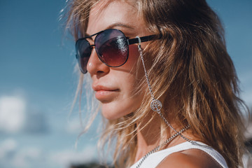 Pretty woman posing in the sea, blue sky, hair wild, victory hand up!, outdoor portrait hipster, fashion model, pretty female, denim shorts, hippie, tattoo, hipster girl, Amsterdam, denim shorts,cute 